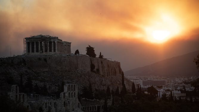 This photo shows the Parthenon temple on the Acropolis hill in a cloud of smoke from a wildfire in Athens on August 12, 2024. On August 12, 2024, Greek civil protection authorities ordered the evacuation of several towns in the northeastern suburbs of Athens threatened by a fierce fire that broke out the previous day and was spreading. (Photo by Angelos TZORTZINIS / AFP) (Photo by ANGELOS TZORTZINIS/AFP via Getty Images)