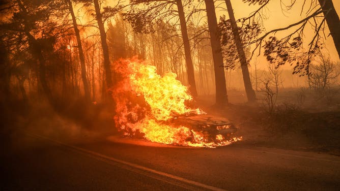 A burning car during the East Attica wildfire in Varnavas, northeast of Athens, Greece, Sunday, Aug. 11, 2024. Several wildfires broke out in Greece on Sunday, including in areas near the capital, and a red alert was imposed in large parts of the country. Photographer: Nick Paleologos/Bloomberg via Getty Images