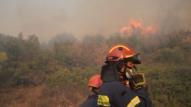 Firefighters work during a forest fire in Varnavas, north of Athens, on August 12, 2024. Greece is battling multiple wildfires on August 11, with smoke shrouding parts of the capital Athens in haze, while extreme weather warnings are in place for the rest of the week. (Photo by Dimitris Lampropoulos/NurPhoto via Getty Images)