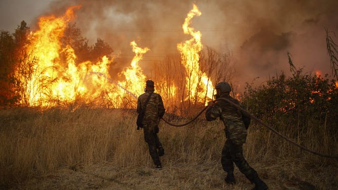 12 August 2024, Greece, Athen: Volunteers extinguish a forest fire in Ano Patima near Penteli in the northern Athens region. Just a few kilometers northeast of the Greek capital, firefighters are battling countless fires over an area of around 200 square kilometers. The government has now asked the EU for support. Photo: Socrates Baltagiannis/ (Photo by Socrates Baltagiannis/picture alliance via Getty Images)