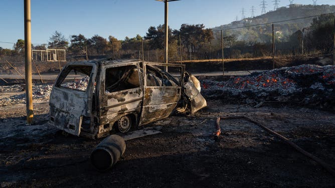 A burned out vehicle following a wildfire in Penteli, on the outskirts of Athens, Greece, on Tuesday, Aug. 13, 2024. Climate change is turbo-charging the threat posed by wildfires, with Greece suffering its worst season in two decades. Photographer: Ioana Epure/Bloomberg via Getty Images