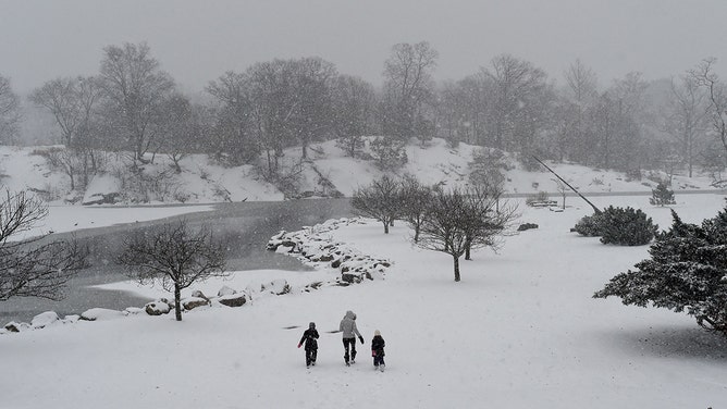 A family walks through the snow in Bruce Park in Greenwich, Connecticut, on December 17, 2016, where temperatures were 29 degrees.