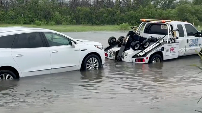 A tow truck assists a stranded driver and their vehicle.