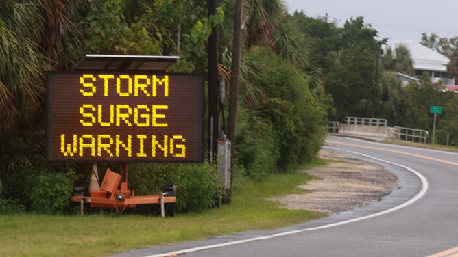 sign warns of a storm surge before the possible arrival of Tropical Storm Debby, which is strengthening as it moves through the Gulf of Mexico on August 04, 2024 in Cedar Key, Florida. Forecasters say Tropical Storm Debby could become a hurricane as soon as Sunday evening, bringing rain storms and high winds along Florida’s west coast. (Photo by Joe Raedle/Getty Images)