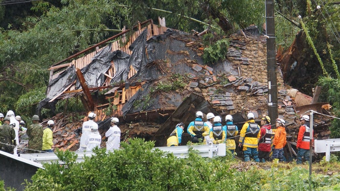 This photo shows rescue workers outside a house that was hit by a landslide in Gamagori, Aichi prefecture on August 28, 2024. 