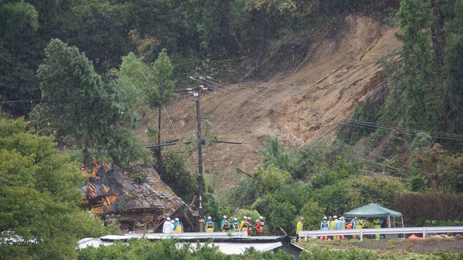 This photo shows rescue workers outside a house that was hit by a landslide in Gamagori, Aichi prefecture on August 28, 2024.