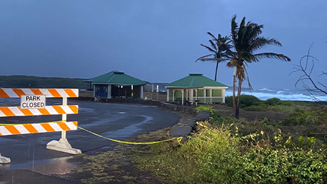 This image shows a park closed sign as large waves kicked up by Hurricane Hone along the Black Sand Beach in Punalu'u on Hawaii's Big Island on Sunday, Aug. 25, 2024.