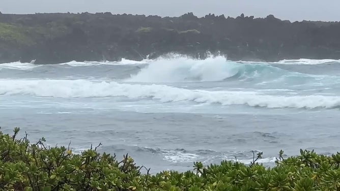 This image shows large waves crashing onshore as Hurricane Hone spins to the south of Hawaii.