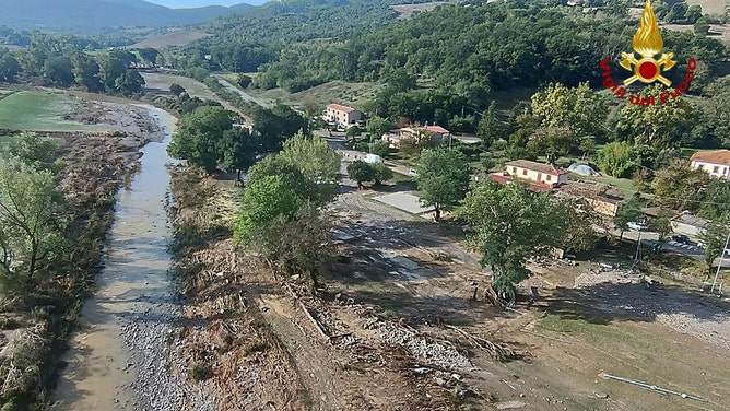 Aerials show flooded area as search goes on for two missing in Tuscany.