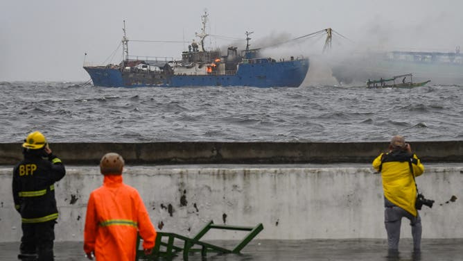 A ship is seen on fire along Manila Bay amid heavy rains brought by Tropical Storm Yagi in Manila on September 2, 2024. A tropical storm dumped heavy rain in the Philippines for a second day on September 2, causing floods and landslides that have left at least four people dead, including a nine-month-old girl, officials said. (Photo by JAM STA ROSA / AFP) (Photo by JAM STA ROSA/AFP via Getty Images)