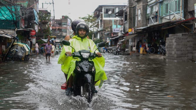 TONDO, MANILA, PHILIPPINES - SEPTEMBER 02: A stilt motorcyclist drives through a flooded road, at the coastal town of Tondo where the poorest of the poor reside in, after Typhoon Yagi (Enteng) brought strong winds and heavy rains to the country, in Tondo, Manila, the Philippines, on September 2, 2024. The tropical storm slicing off the coast of the Southeast Asian archipelagos has forced schools and work in some regions to suspend, flights canceled, and caused flooding and landslides. Officials said at least four individuals have died, including a nine-month-old girl in the eastern city of Nega. (Photo by Daniel Ceng/Anadolu via Getty Images)