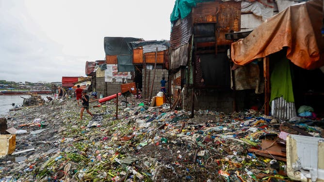 TONDO, MANILA, PHILIPPINES - SEPTEMBER 02: People clean up rubbish washed offshore at the stilt houses in the costal town of Tondo where the poorest of the poor reside in, after Typhoon Yagi (Enteng) brought strong winds and heavy rains to the country, in Tondo, Manila, the Philippines, on 2 September, 2024. The tropical storm slicing off the coast of the Southeast Asian archipelagos has forced schools and work in some regions to suspend, flights canceled, and caused flooding and landslides. Officials said at least four individuals have died, including a nine-month-old girl in the eastern city of Nega. (Photo by Daniel Ceng/Anadolu via Getty Images)
