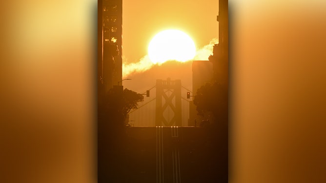 Sun rises over the Bay Bridge and California Street as called 'California Henge' in San Francisco, California, United States on September 2, 2024.