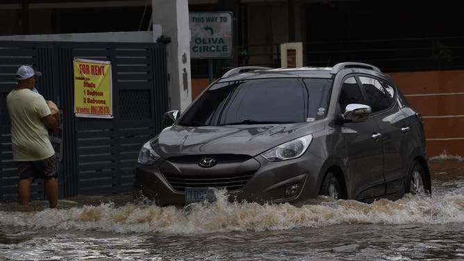 A resident wades through a flooded street following heavy rains brought about by Tropical Storm Yagi at a village in Cainta town, Rizal province, East of Manila on September 3, 2024. Floods and landslides killed 11 people after a fierce tropical storm dumped heavy rain on the Philippines for a second day, officials said September 2. (Photo by Ted ALJIBE / AFP) (Photo by TED ALJIBE/AFP via Getty Images)