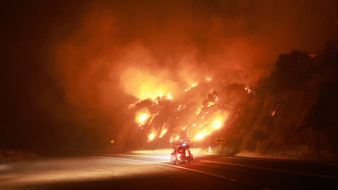 A resident drives their car packed with belongings as Highway 330 is engulfed by the Line Fire near Running Springs, California, on September 7, 2024. California Governor Gavin Newsom and San Bernardino County authorities declared a state of emergency on September 8. The Line Fire has burned more than 7,000 acres (2,800 hectares). (Photo by DAVID SWANSON / AFP) (Photo by DAVID SWANSON/AFP via Getty Images)