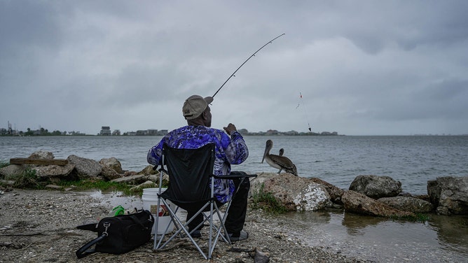 Lucius Rhone fishes as a storm rolls through the coast ahead of Hurricane Francine on Tuesday, Sept. 10, 2024 in Galveston.