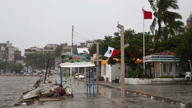 A Mexican flag is pictured under the rain after the passage of hurricane John in Acapulco, Mexico on September 24, 2024.