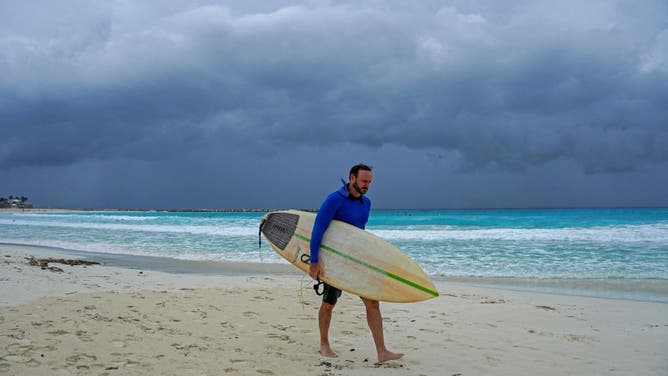 A surfer leaves the beach ahead of the arrival of Hurricane Helene in Cancun, Quintana Roo state, Mexico, September 24, 2024.