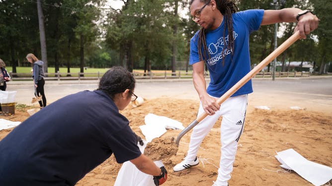 TALLAHASSEE, FLORIDA - SEPTEMBER 25: Jordan Rochester, right, and Kyley Weems gather sand in preparation for possible flooding on September 25, 2024 in Tallahassee, Florida. Forecasts call for Tropical Storm Helene to strengthen into a hurricane and make landfall along Florida's Gulf Coast on Thursday. (Photo by Sean Rayford/Getty Images)