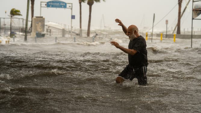 GULFPORT, FL - SEPTEMBER 26: A man crosses a storm surge flooded area on the coast of Gulfport, Fla. as Hurricane Helene passed through the Gulf of Mexico to the West on September 26, 2024. (Photo by Thomas Simonetti for The Washington Post via Getty Images)