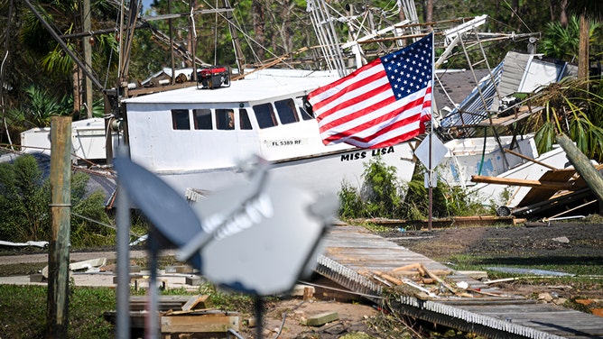 A boat pushed ashore by Hurricane Helene lies on dry ground in Keaton Beach, Florida, September 27, 2024.