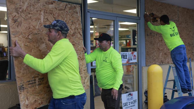 CLEARWATER, FLORIDA - SEPTEMBER 25: Workers place plywood over the windows of a business before the arrival of Hurricane Helene on September 25, 2024, in Clearwater, Florida. Hurricane Helene is forecast to become a major hurricane, bringing the potential for deadly storm surges, flooding rain, and destructive hurricane-force winds along parts of the Florida West Coast. Helene is expected to make landfall in Florida on Thursday. (Photo by Joe Raedle/Getty Images)