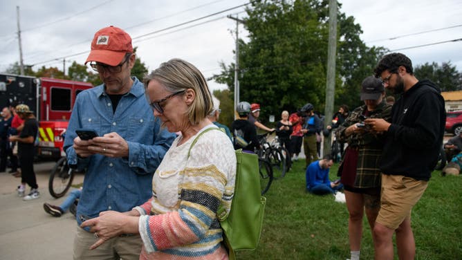 Residents gather at Fire Station number 6 to access WiFi after heavy rains from Hurricane Helene caused record flooding and damage on September 28, 2024 in Asheville, North Carolina.