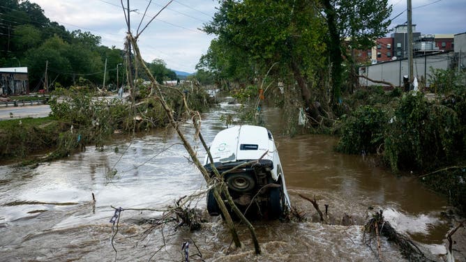 A van is partially submerged in the Swannanoa River at Biltmore Village following Hurricane Helene on September 29, 2024 in Asheville, North Carolina.