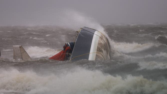 ST PETERSBURG, FLORIDA - SEPTEMBER 2: A capsized boat washes ashore as Hurricane Helene churns offshore on September 26, 2024 in St. Peteersburg Florida. Already a Category 3 storm, Helene was expected to gain further strength before making landfall this evening on Florida’s northwestern coast. Flash flood warnings extend to northern Georgia and western North Carolina. (Photo by Joe Raedle/Getty Images)