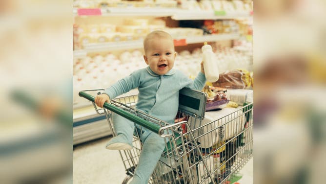 Baby smiling in shopping cart in grocery store