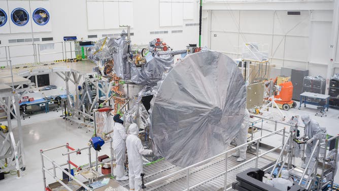 Engineers and technicians install a 10-foot high-gain antenna on NASA's Europa Clipper spacecraft on Aug. 14, 2023. The orbiter is being assembled in the High Bay 1 clean room of the Spacecraft Assembly Facility at the agency's Jet Propulsion Laboratory (JPL).