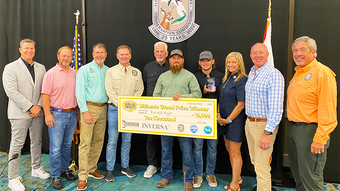 Ronald Kiger, center, with a check for a $10,000 after capturing 20 pythons during the 2024 Florida Python Challenge. 