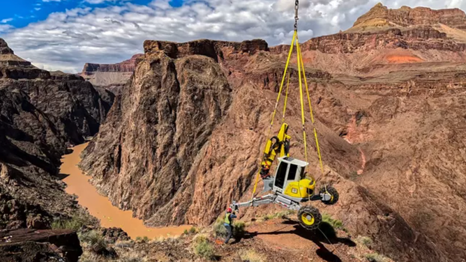 A helicopter delivers construction equipment in the park for the Transcanyon Waterline project.