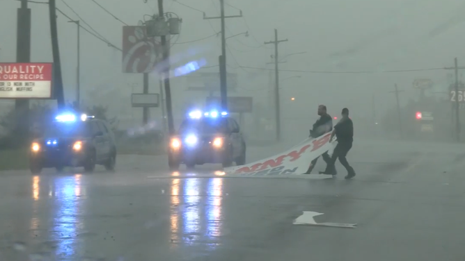 Police removing sign from road.