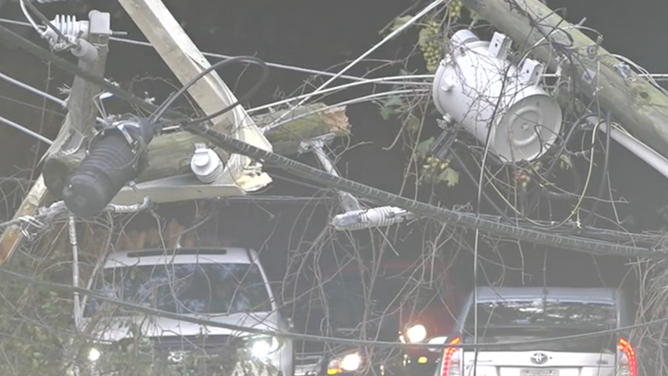 Cars drive under broken power lines.