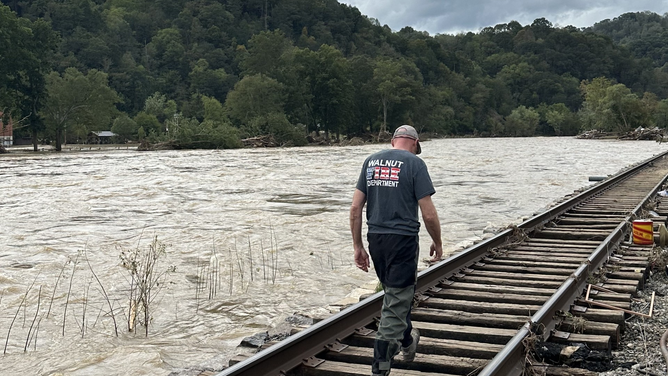 Flooding along the French Broad River and a member of the Walnut Fire Department Swift Water Rescue team after Hurricane Helene.