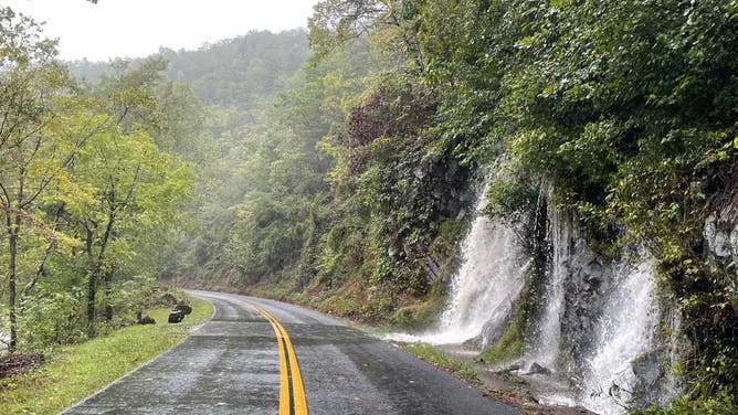 Floodwater pours onto road.