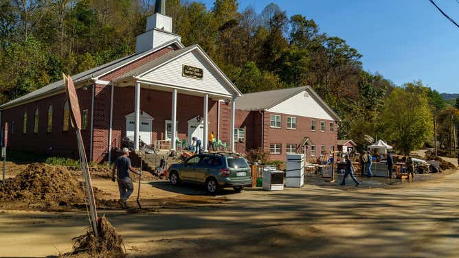 North Carolina National Guard soldiers assigned to the 5th Battalion, 113th Field Artillery Regiment, 236th Brigade Engineer Battalion, and the 230th Brigade Support Battalion, moves a muddy refrigerator while helping church members and volunteers clean out flooded church basement at Cove Creek Baptist Church in Vilas, North Carolina, Oct. 12, 2024.