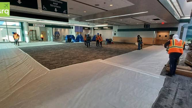 Photo shows workers in the Sarasota-Bradenton International Airport completing repairs to Concourse B.
