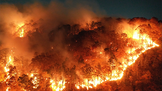 This dramatic image shows intense flames scorching the landscape on Lamentation Mountain in Berlin, Connecticut, on Monday, Oct. 21, 2024.