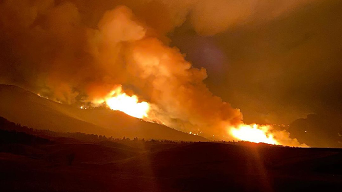 Flames from the Elk Fire are seen within Wyoming's Bighorn National Forest on Oct. 11, 2024.