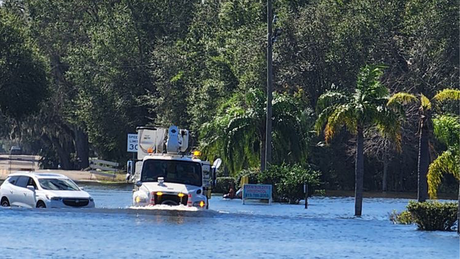 A Duke Energy truck driving through flood waters in Florida after Hurricane Milton.