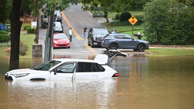 A car in a flooded street is seen after Hurricane Helene made landfall in Atlanta, Georgia, on September 27, 2024. Hurricane Helene weakened on September 27 hours after it made landfall in the US state of Florida, with officials warning the storm remained "extremely dangerous" as it surged inland, leaving flooded roads and homes in its wake. (Photo by Richard PIERRIN / AFP) (Photo by RICHARD PIERRIN/AFP via Getty Images)