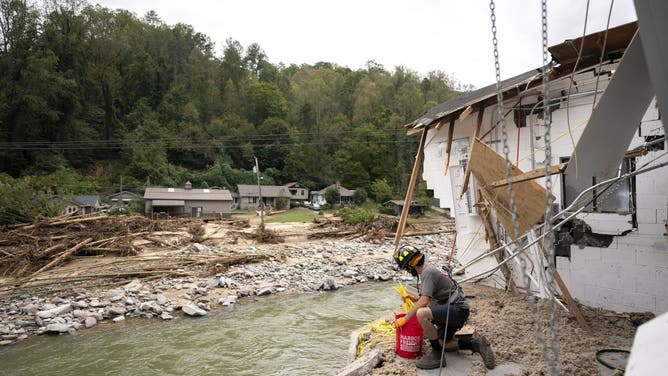 BAT CAVE, NORTH CAROLINA - OCTOBER 1: Avery Sherrill salvages what he can from his destroyed family business, Mudtools, along the Broad River in the aftermath of Hurricane Helene on October 1, 2024 in Bat Cave, North Carolina. The death toll has topped 140 people across the southeastern U.S. due to the storm, according to published reports, which made landfall as a category 4 storm on Thursday. Millions are without power and the federal government has declared major disasters in areas of North Carolina, Florida, South Carolina, Tennessee, Georgia, Virginia and Alabama, freeing up federal emergency management money and resources for those states, according to the reports. (Photo by Sean Rayford/Getty Images)