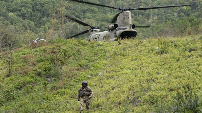 BAT CAVE, NORTH CAROLINA - OCTOBER 1: A member of the Maryland National Guard descends a hill at a supply drop point in the aftermath of Hurricane Helene on October 1, 2024 near Bat Cave, North Carolina. The death toll has topped 140 people across the southeastern U.S. due to the storm, according to published reports, which made landfall as a category 4 storm on Thursday. Millions are without power and the federal government has declared major disasters in areas of North Carolina, Florida, South Carolina, Tennessee, Georgia, Virginia and Alabama, freeing up federal emergency management money and resources for those states, according to the reports. (Photo by Sean Rayford/Getty Images)