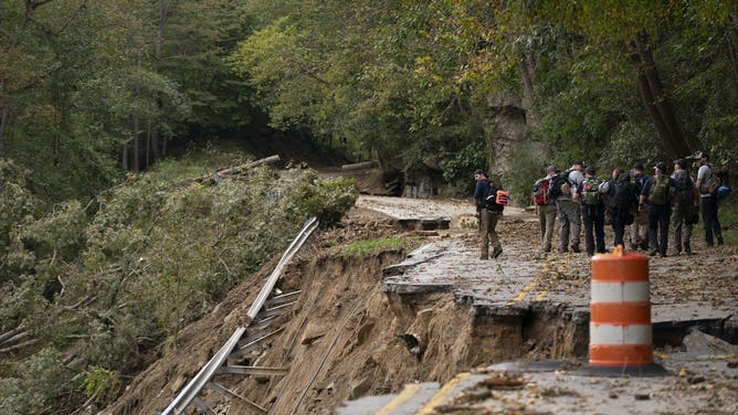 BAT CAVE, NORTH CAROLINA - OCTOBER 1: A search and rescue team walks along North Carolina Route 9 in the aftermath of Hurricane Helene on October 1, 2024 in Bat Cave, North Carolina. The death toll has topped 140 people across the southeastern U.S. due to the storm, according to published reports, which made landfall as a category 4 storm on Thursday. Millions are without power and the federal government has declared major disasters in areas of North Carolina, Florida, South Carolina, Tennessee, Georgia, Virginia and Alabama, freeing up federal emergency management money and resources for those states, according to the reports. (Photo by Sean Rayford/Getty Images)