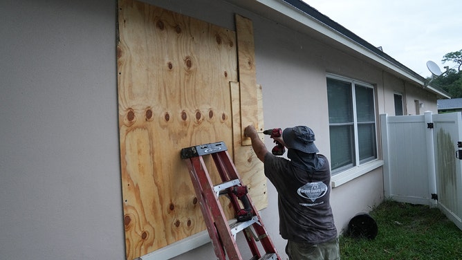 A resident boards up his windows in Palm Harbor, Florida, ahead of Hurricane Milton's expected mid-week landfall on October 6, 2024.