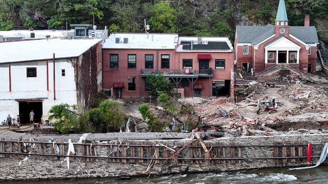 In an aerial view, flood damage, including mangled railroad tracks, wrought by Hurricane Helene is seen along the French Broad River on October 3, 2024 in Marshall, North Carolina.