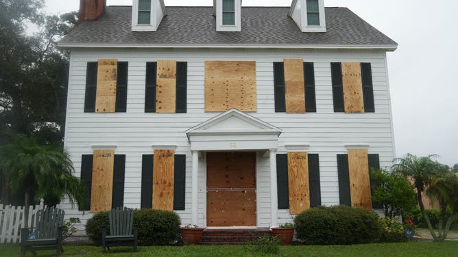 A boarded up house for sale in the the front yard in Dunedin ahead of Hurricane Milton's expected landfall tonight on October 9, 2024 in Florida. Milton regained power on October 8 to become a Category 5 storm with maximum sustained winds of 165 mph (270 kph) as it barrels towards the west-central coast of Florida and is forecast to make landfall late October 9, according to the National Hurricane Center. (Photo by Bryan R. SMITH / AFP) (Photo by BRYAN R. SMITH/AFP via Getty Images)