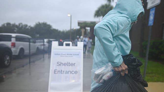 People arrive to shelter buffalo creek middle school ahead of Hurricane Milton expected landfall in Bradenton, Florida on October 9, 2024. Milton regained power on October 8 to become a Category 5 storm with maximum sustained winds of 165 mph (270 kph) as it barrels towards the west-central coast of Florida and is forecast to make landfall late October 9, according to the National Hurricane Center. (Photo by Miguel J. Rodriguez Carrillo / AFP) (Photo by MIGUEL J. RODRIGUEZ CARRILLO/AFP via Getty Images)
